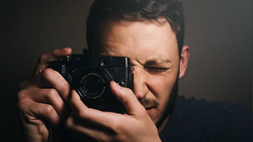 Close up image of a professional photographer taking a custom photo with a camera