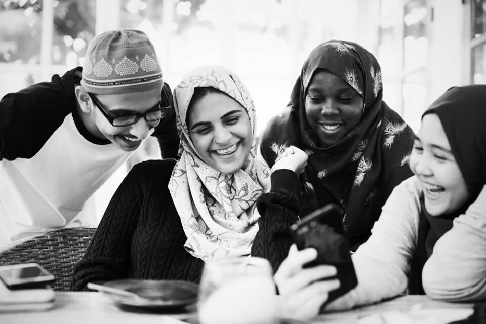 Young group of arab friends interacting with digital media on a mobile device